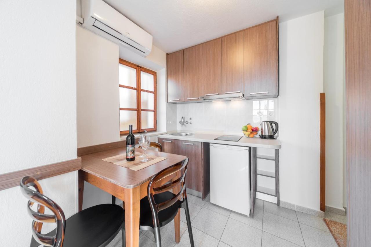 Kitchenette with wooden dining table in a studio at R Club Apartments