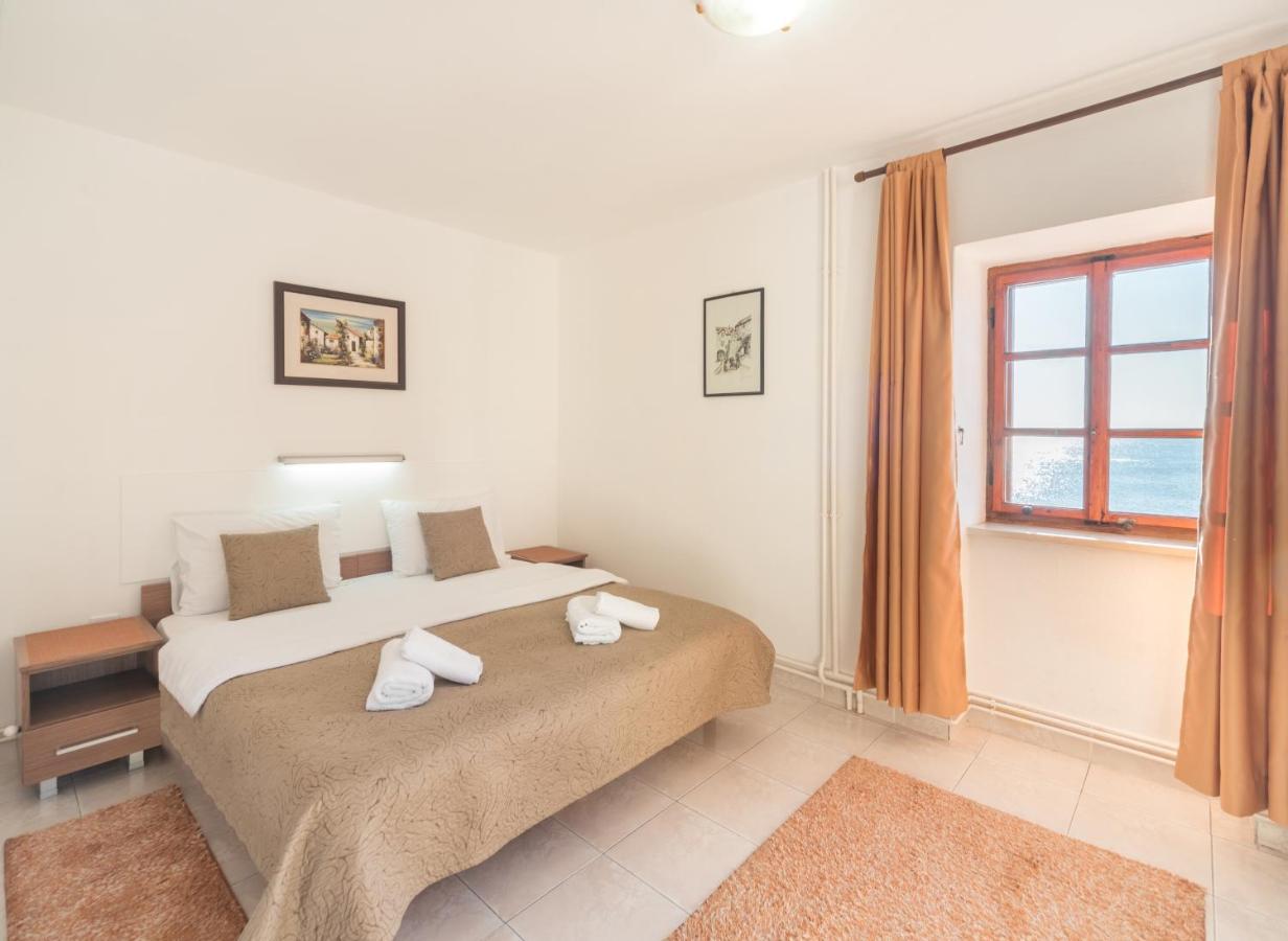 Bedroom with a large bed and window in Budva Old Town apartment
