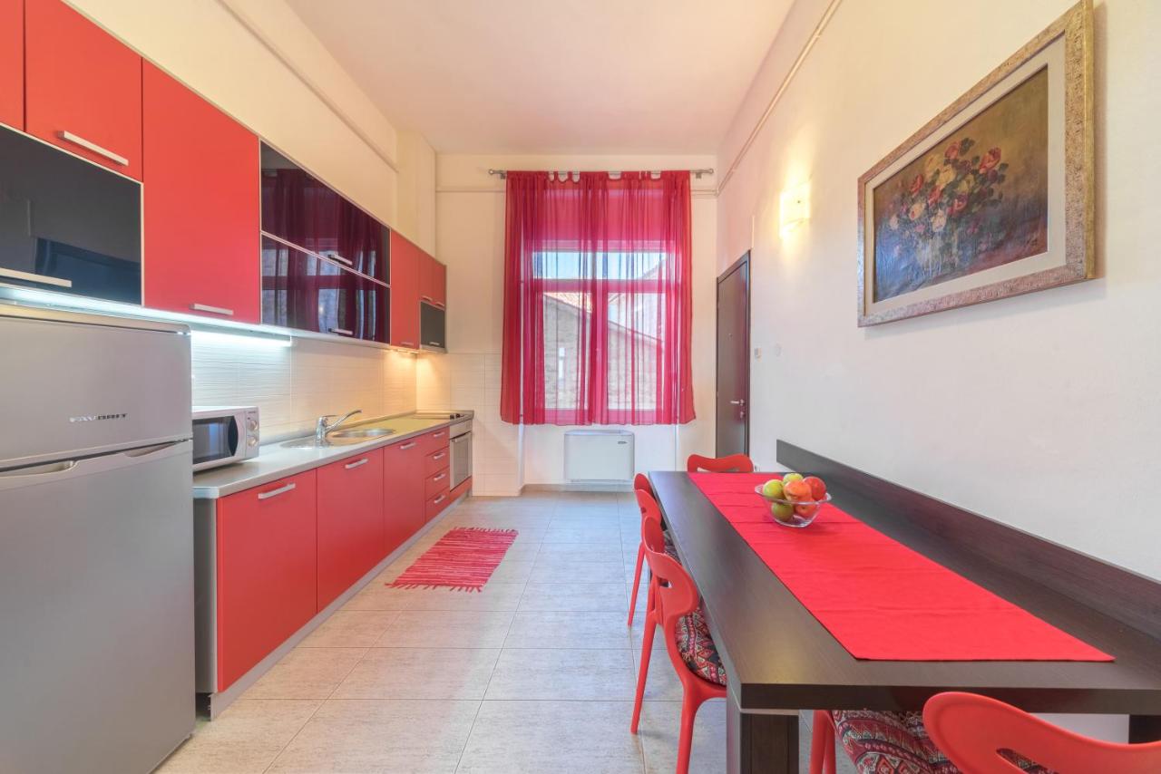 Kitchen with red cabinetry and dining table at R Club Apartments Budva