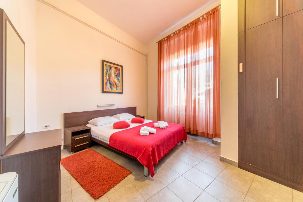 Bedroom with red bedding at R Club Apartments Budva